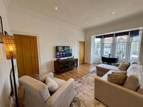 a living room with two couches and a flat screen tv at Allards Apartment, Central Tynemouth in Tynemouth