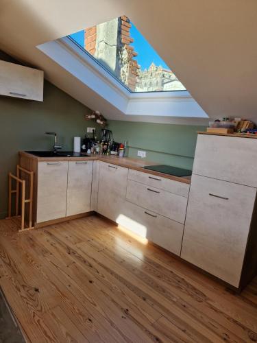 une cuisine mansardée avec une lucarne au plafond dans l'établissement Le nid de Raphaël rooftop, au Puy-en-Velay
