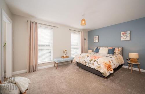 a bedroom with a bed and two windows at BridShu Den New build Townhouse in Larne