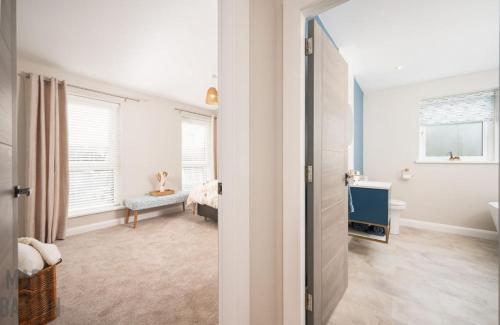 a white room with a bedroom and a bathroom at BridShu Den New build Townhouse in Larne