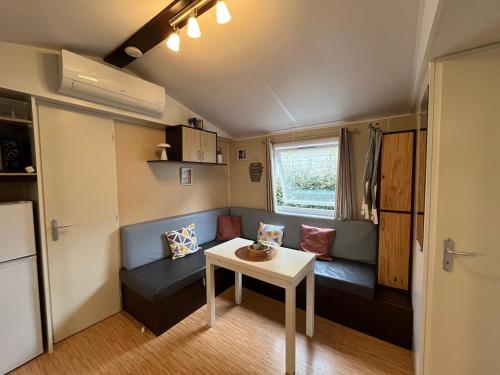 un petit salon avec un canapé et une table dans l'établissement Mobil-Home - Climatisé, 6 couchages - Camping 1 Étoile, aux Mathes