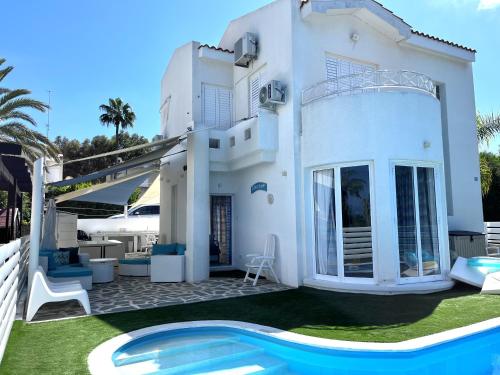 a white villa with a swimming pool in front of it at STAY ALKYONI Villa in Protaras