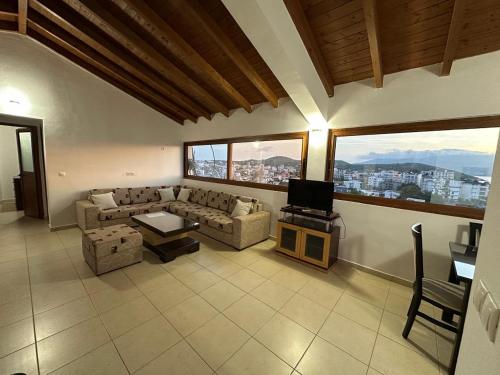 a living room with a couch and a tv at Hotel Marku in Ksamil