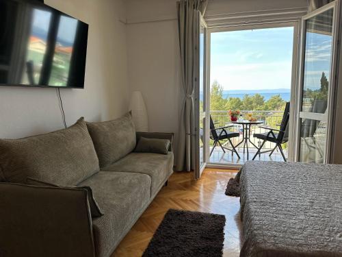 ein Wohnzimmer mit einer Couch und einem Tisch mit Stühlen in der Unterkunft Spacious family apartment near the beach in Makarska