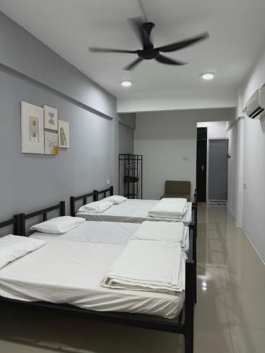 a room with four beds and a ceiling fan at Modern & Cozy Home Stay in Kampar