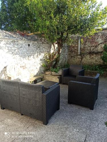 trois chaises en osier et une table et un arbre dans l'établissement Charmante maison proche de toutes commodités, à Croix