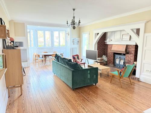 un salon avec un canapé vert et une table dans l'établissement L'Orénoque Duplex en forêt, à Le Touquet-Paris-Plage