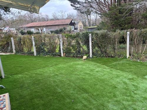 une cour avec une pelouse verdoyante et une clôture dans l'établissement Maison en pierre, à Saint-Germain-dʼEsteuil