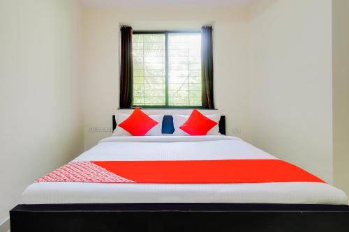 a red and white bed in a room with a window at Hotel O Galaxy Near INOX in Yeraoda