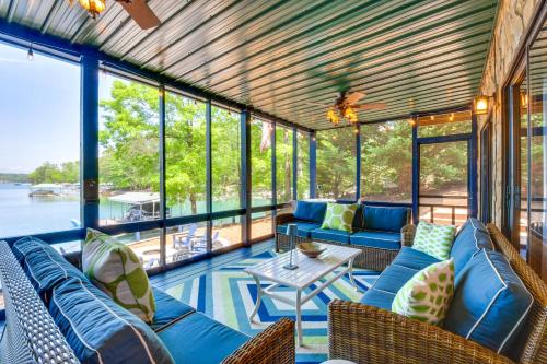 a screened in porch with blue couches and a table at Beautiful Lake Keowee Home with Boat Dock and Fire Pit in Seneca