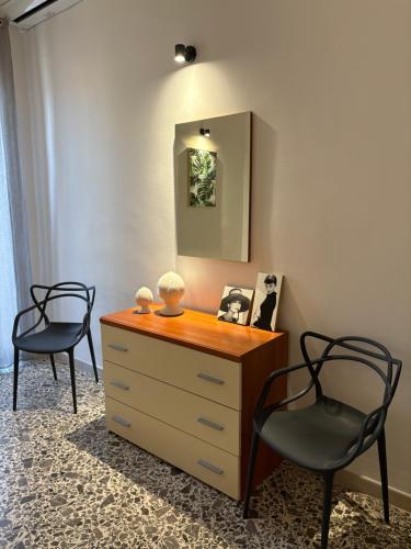two chairs and a dresser in a room with a mirror at La Casa verde in Galatone