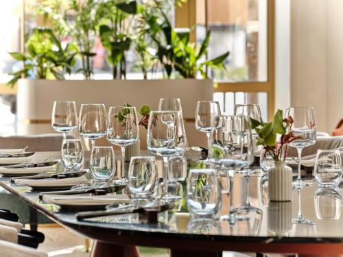 a table with wine glasses and plates on it at Mövenpick Grand Hotel Wroclaw in Wrocław