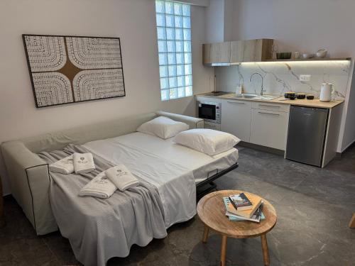 ein Zimmer mit zwei Betten und einem Tisch und einer Küche in der Unterkunft Heleon Luxury Apartments in Parga