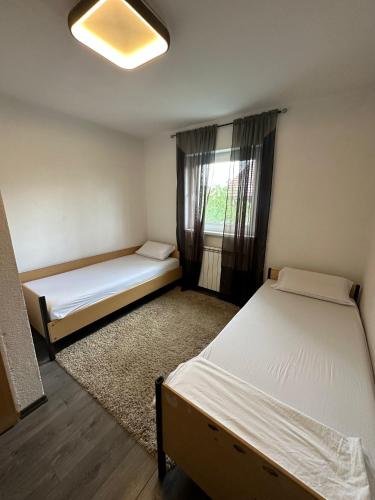 a small room with two beds and a window at Kovači Residence in Hrasnica