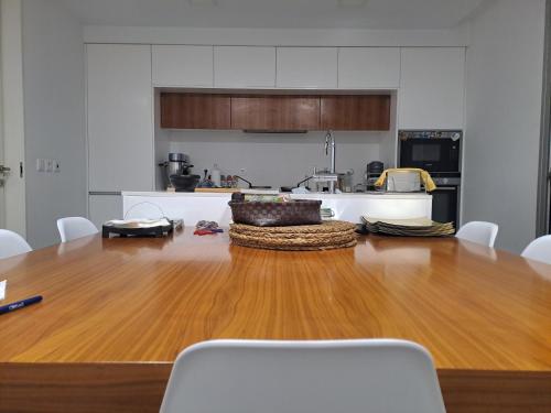 a kitchen with a large wooden table and white cabinets at Esposende Resort - Golf, Beach, River, Tennis, Pool in Gemezes