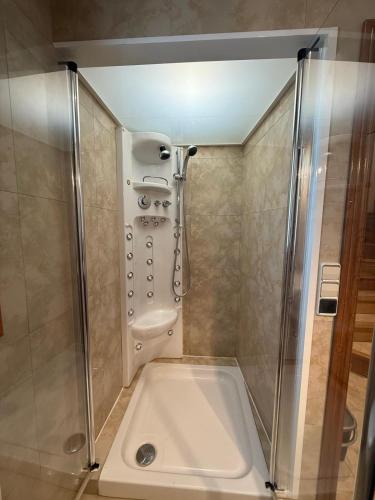 a bathroom with a shower and a tub at Vila Mont Rebei in Tolva