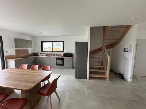 une cuisine avec une table et des chaises ainsi qu'un escalier dans l'établissement Les Libérateurs, à Bayeux