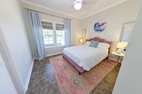 - une chambre avec un lit blanc et 2 fenêtres dans l'établissement Bella's Charming Cottage, à Thomasville