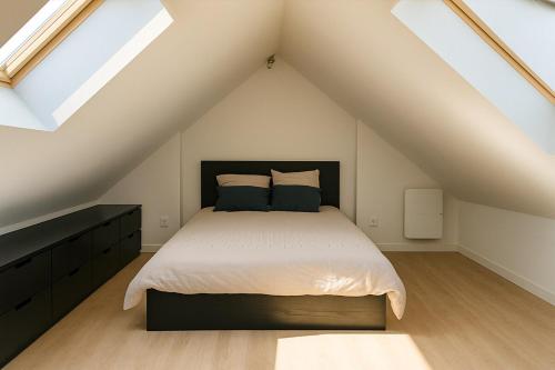 une chambre avec un grand lit dans un grenier dans l'établissement Cozy Duplex Lille Centre Design & Quiet, à Lille