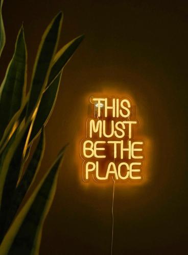 a neon sign that says this must be the place at Lovely Sparkly Apartment in Krakow