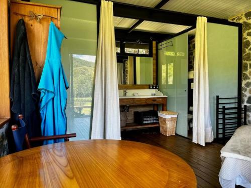 ein Esszimmer mit einem Holztisch und ein Badezimmer in der Unterkunft Fazenda Caminho do Ouro in São José do Barreiro