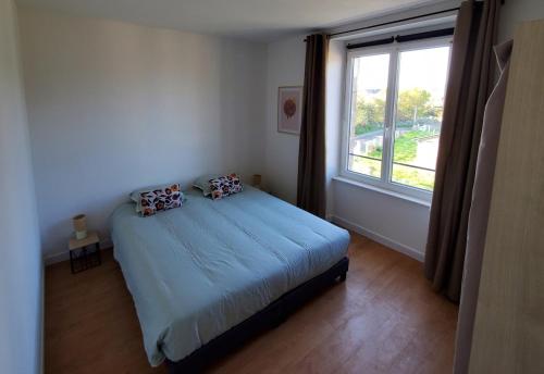 a bedroom with a bed and a large window at L'Évasion Maison typique de mineur in Flamanville