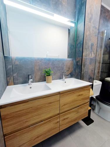 une salle de bain avec un lavabo blanc et un miroir dans l'établissement T2 Moderne en Bord de plage, au Barcarès