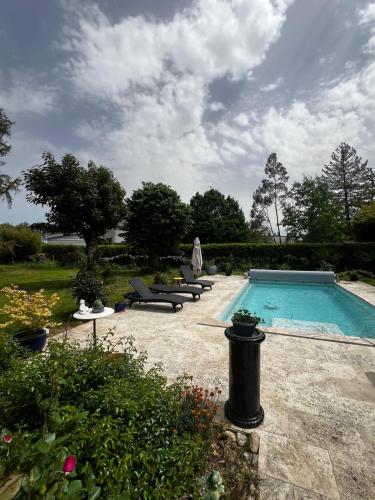 - une piscine avec plusieurs chaises longues à côté dans l'établissement Chez Patricia, à Brens