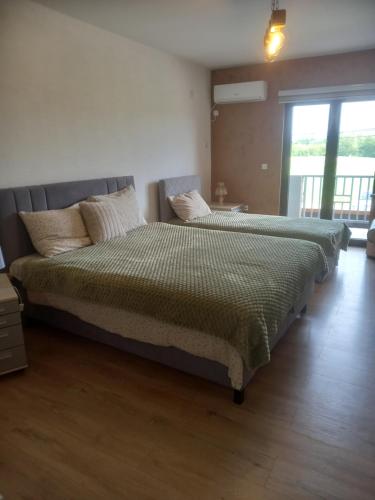 a bedroom with two beds and a large window at Apartman Ika 1N in Kraljevo