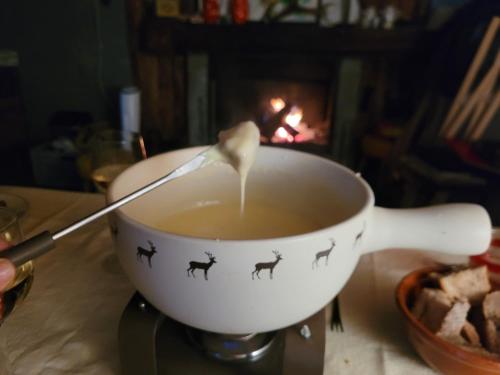 a person stirring a bowl of soup with a spoon at Rustico Cascina Val Malvaglia in Malvaglia