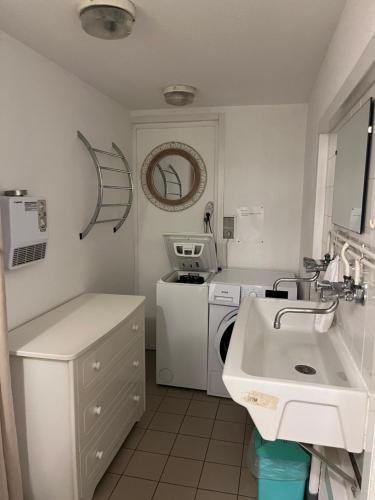 a white laundry room with a washer and a sink at La maison des vendangeurs in Vergisson