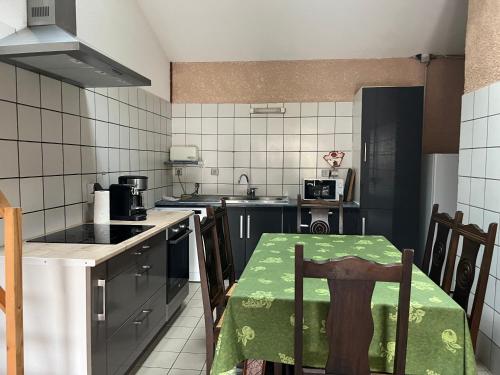 une cuisine avec une table et un tissu de table vert dans l'établissement La maison des vendangeurs, à Vergisson