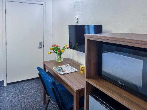 a room with a desk with a television and a table at Golden North Inn in Fairbanks