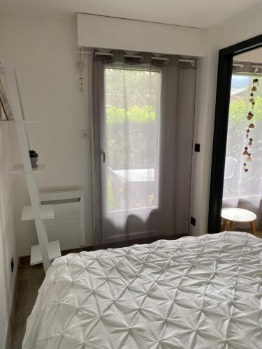a bedroom with a bed and a large window at MONT BLANC HOLIDAYS dans résidence avec Gardien in Sallanches