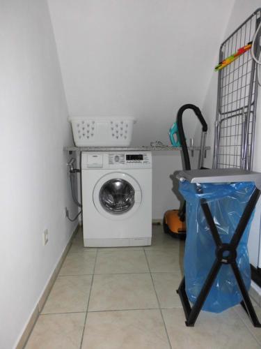 a laundry room with a washing machine and a table at Bakumara in Bakum
