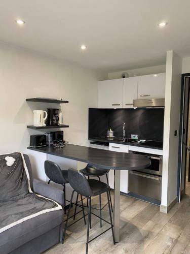 une cuisine avec une table, des chaises et un canapé dans l'établissement MONT BLANC HOLIDAYS dans résidence avec Gardien, à Sallanches