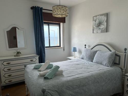 a bedroom with a bed with a mirror and a window at Casa do Mar in Salema