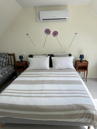 - une chambre avec un lit orné de fleurs violettes sur le mur dans l'établissement Gite des 3 sœurs, à Vernon