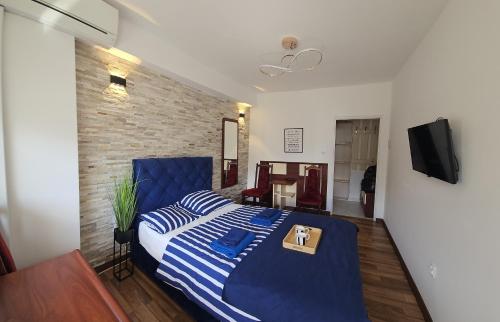 a bedroom with a blue bed and a tv at Sea View Slavia in Międzyzdroje