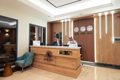 two people sitting at a reception counter in a salon at فندق واحة روز in Jeddah