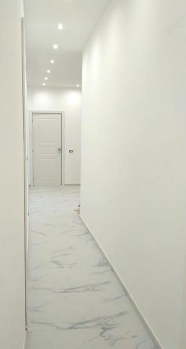 an empty hallway with white walls and a white door at Villa Anna al Duomo in Taormina