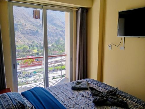 a bedroom with a bed and a large window at Restobar & Hotel Campestre Aisha in Cocachacra
