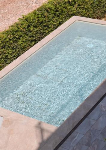 a pool of water in a yard with grass at Villa Florale in Široka