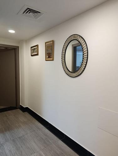 a white room with a mirror on a wall at 1-Bedroom Family Apartment with Balcony in Sharjah in Sharjah