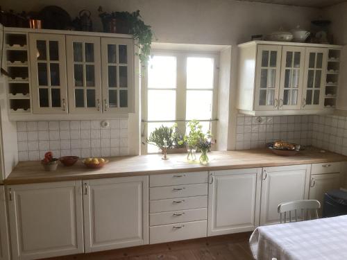a kitchen with white cabinets and a window at Erikslund in Hurva
