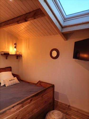a bedroom with a bed and a flat screen tv at Oudoty in Kerlouan
