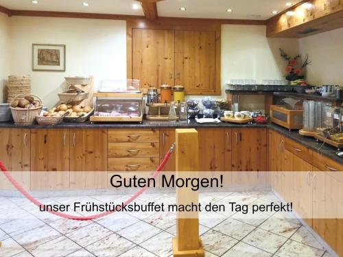 a kitchen with wooden cabinets and a counter top at GarniHotel zur Linde - Bayerischer Wald - aktivCard mit 154 kostenfreien Leistungen - kostenloser Parkplatz in Lohberg