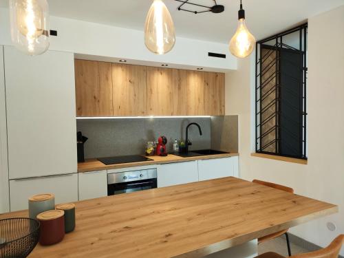 - une cuisine avec une table en bois dans l'établissement T2 moderne, à Balaruc-les-Bains