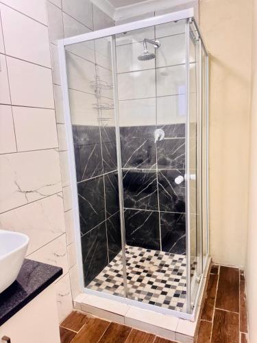 a shower with a glass door in a bathroom at Private Studio in Cape Town, Near Canal Walk & Table Mountain in Cape Town