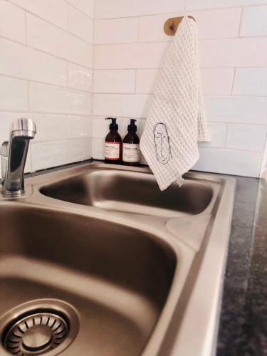 a kitchen sink with a towel hanging over it at Private Studio in Cape Town, Near Canal Walk & Table Mountain in Cape Town